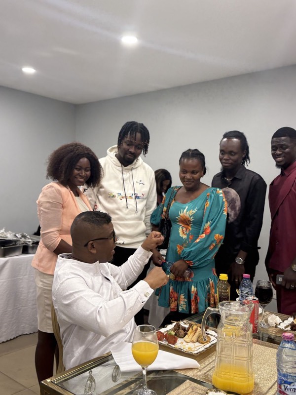 People gathered round a table while a minister ministers