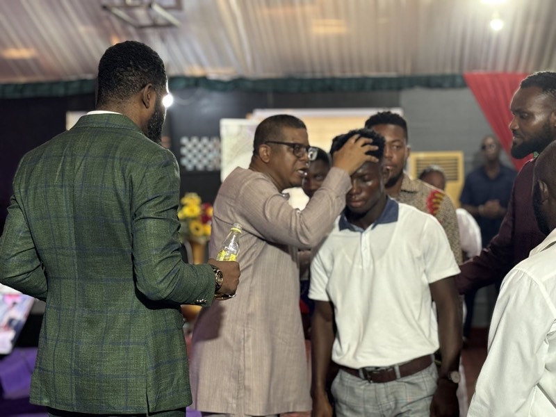 A minister laying hands on a man in prayer